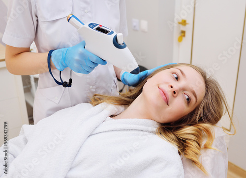 procedure of hardware skin rejuvenation using a cold stream of carbon dioxide CO2. A cosmetologist performs a skin rejuvenation procedure for an attractive woman