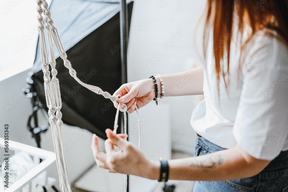 Fototapeta premium Young woman talor weaving macrame cloth