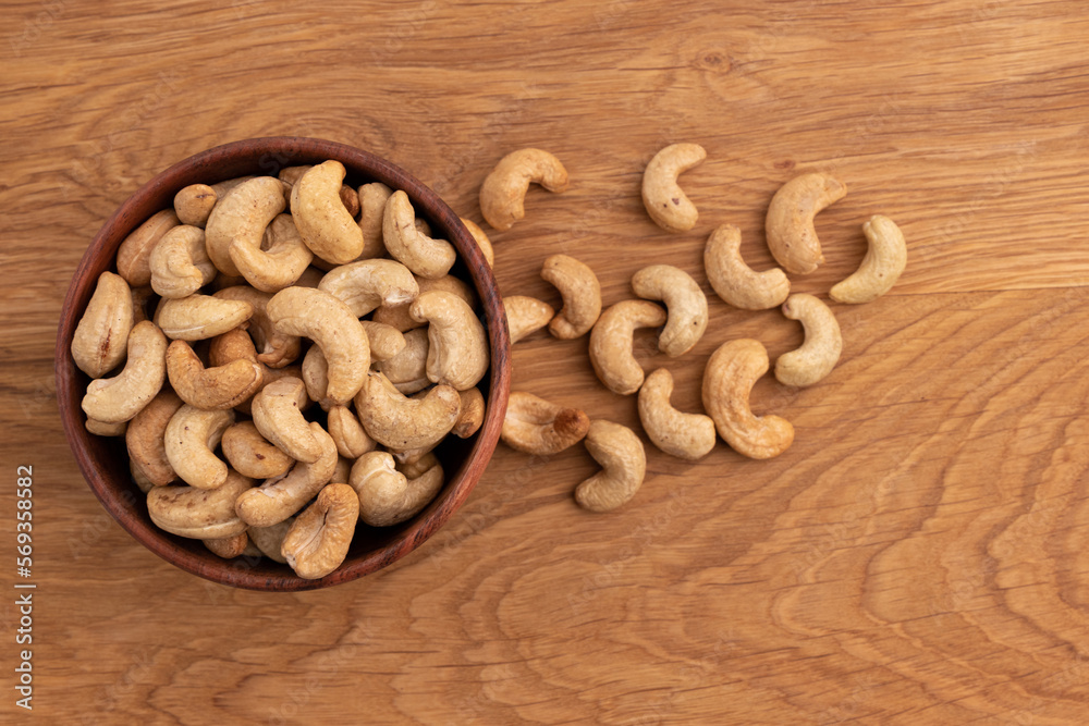 cashew nuts in bowl on wooden background cashew nuts in bowl on wooden background