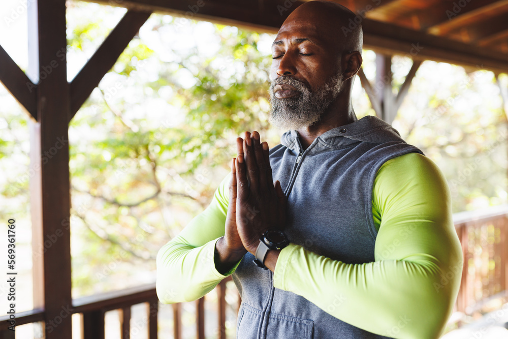 Foto de Bald african american senior man meditating in prayer pose ...