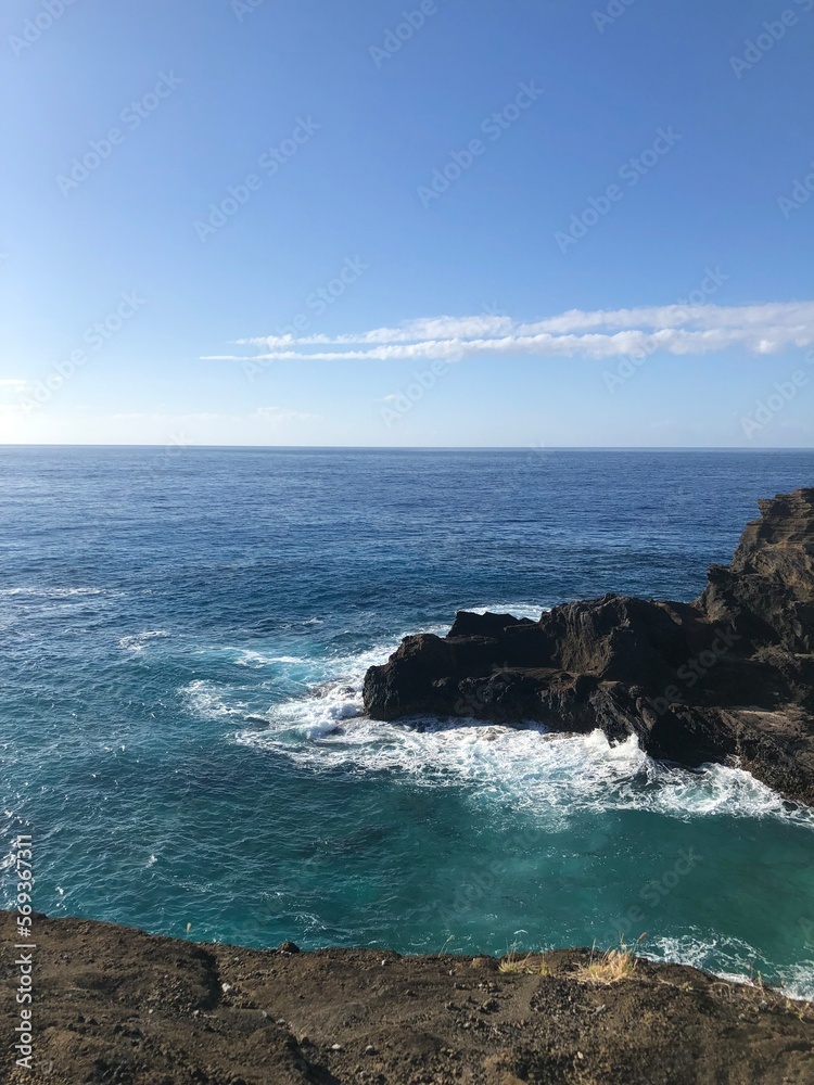 Hawaiian beach view of water crashing against rocks, cliffside, Hawaiian beach water and sky Hawaiian beach view of water crashing against rocks, cliffside, Hawaiian beach water and sky