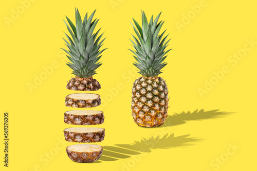 Two fresh juicy pineapples, whole and sliced. Concept. On a yellow background.