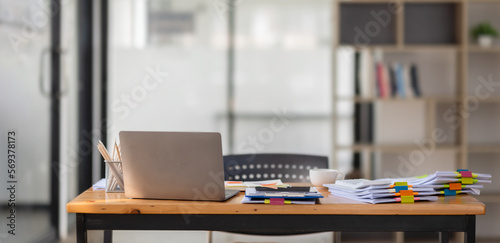 Tableau sur toile Laptop Computer, notebook, and eyeglasses sitting on a desk in a large open plan