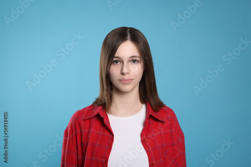 Portrait of teenage girl on light blue background