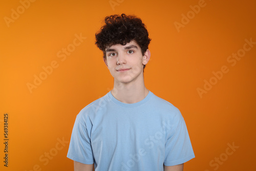 Portrait of cute teenage boy on orange background © New Africa
