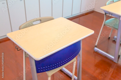 スチールロッカーを背景に置かれたスチール机とイスのクローズアップ。学校、教室のイメージ