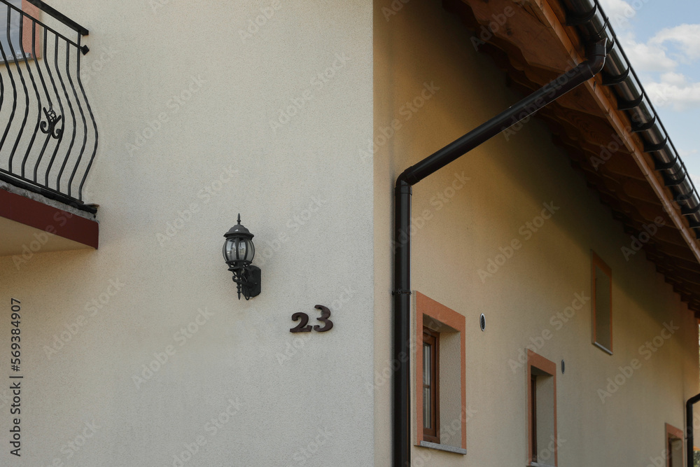 Fototapeta premium Number 23 on yellow house with balconies outdoors