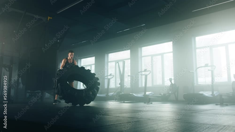 Portrait of a handsome, caucasian guy using heavy rubber to gain lean body muscles. Close-up view of active sportsman looking focused while moving the weights. High quality 4k footage Portrait of a handsome, caucasian guy using heavy rubber to gain lean body muscles. Close-up view of active sportsman looking focused while moving the weights. High quality 4k footage