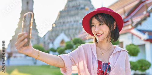 happy thai woman taking seflie at wat arun temple in bangkok thailand photo