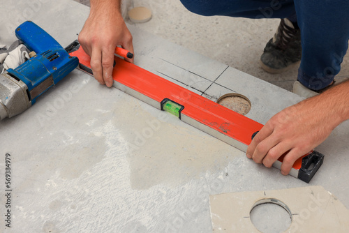 Worker making socket hole in tile indoors, closeup