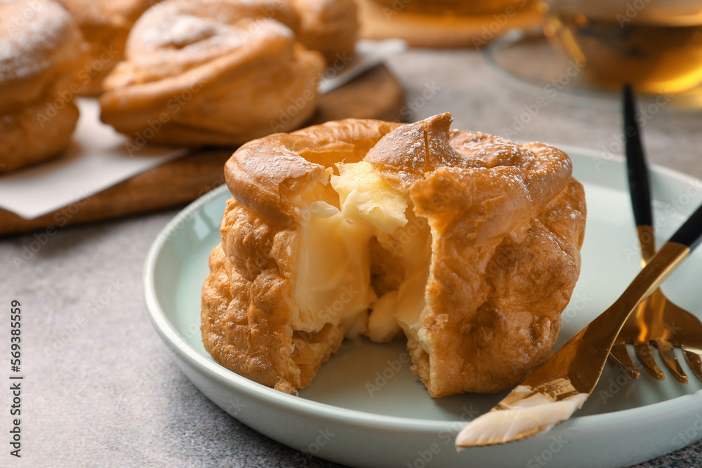 Delicious profiterole filled with cream on grey table, closeup Delicious profiterole filled with cream on grey table, closeup