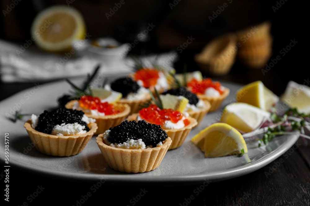 Delicious tartlets with red and black caviar served on table, closeup - obrazy, fototapety, plakaty 