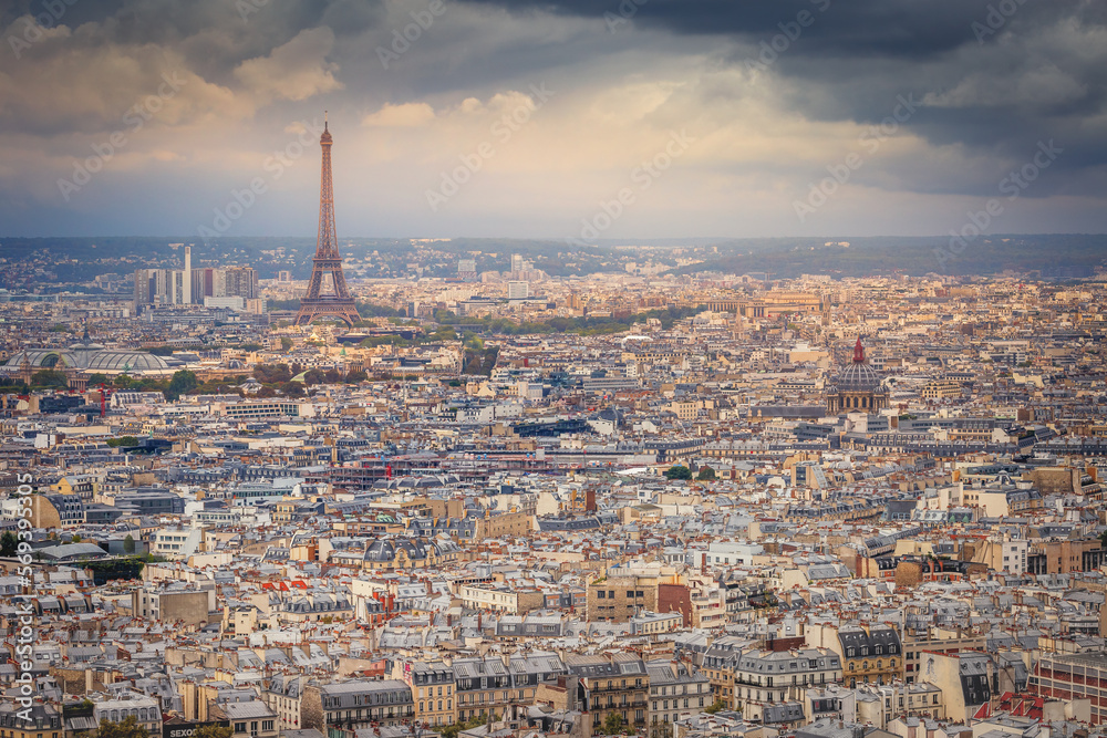 Paris skyline at sunset with Eiffel Tower above parisien roofs, Paris, France