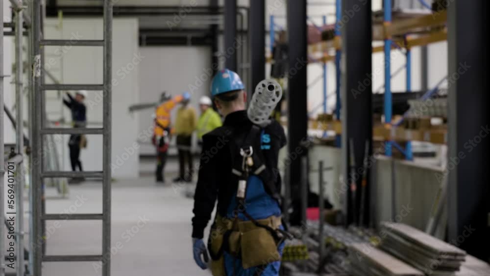 construction worker transporting a metal tube construction worker transporting a metal tube