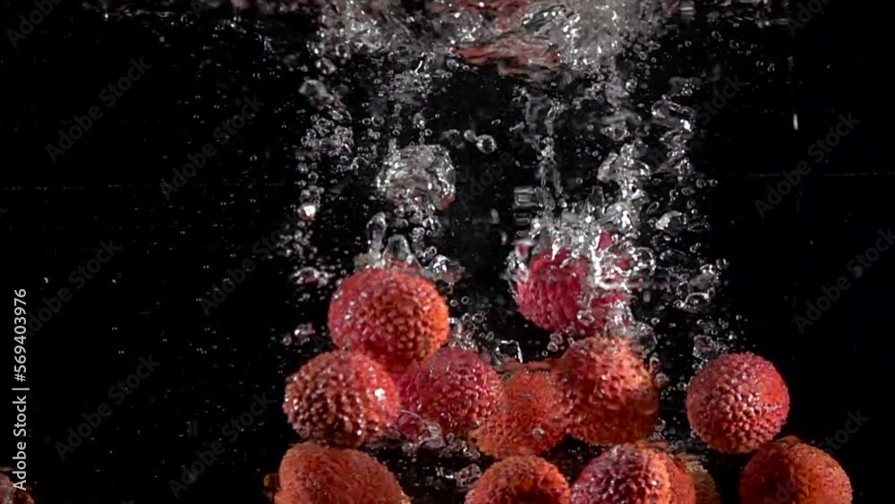 Super slow motion of falling lychee fruit into splashing water. Lemonade cooking concept. Filmed on high speed cinema camera, 4k 1000 fps.