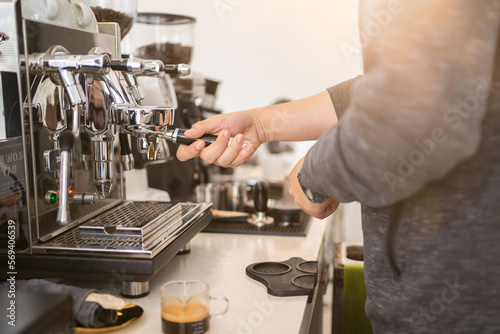 Banner of Asian Barista tamping the portafilter and preparing cup of coffee