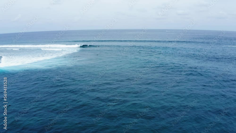 Aerial Lockdown Shot Of People Surfing On Waves In Sea Against Sky - Thulusdhoo, Maldives Aerial Lockdown Shot Of People Surfing On Waves In Sea Against Sky - Thulusdhoo, Maldives