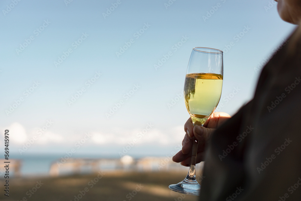 A senior woman drinking wine outdoors.  屋外でワインを飲むシニア女性