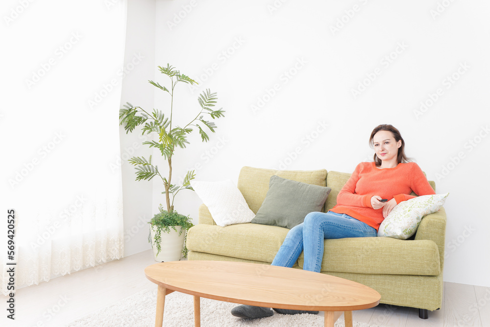 家でテレビを見る女性 家でテレビを見る女性