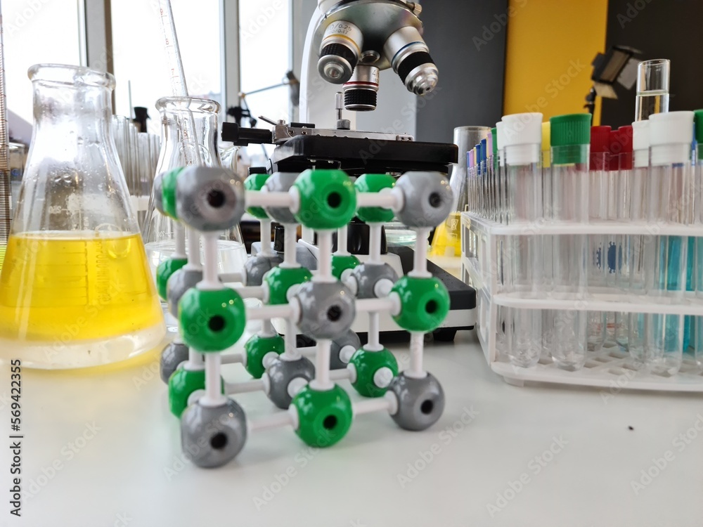 Microscope with many test tubes and a plastic molecule Microscope with many test tubes and a plastic molecule