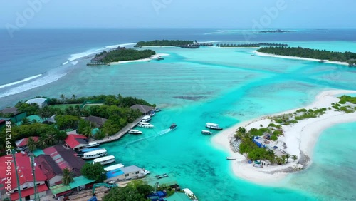 Aerial Panning Beautiful View Of Roofed Hotels On Island Amidst Sea - Thulusdhoo, Maldives photo