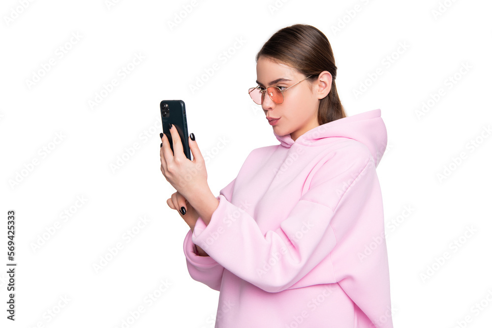 Young woman in casual pink hoodie and glasses taking selfie holding smartphone in hand, video call Young woman in casual pink hoodie and glasses taking selfie holding smartphone in hand, video call