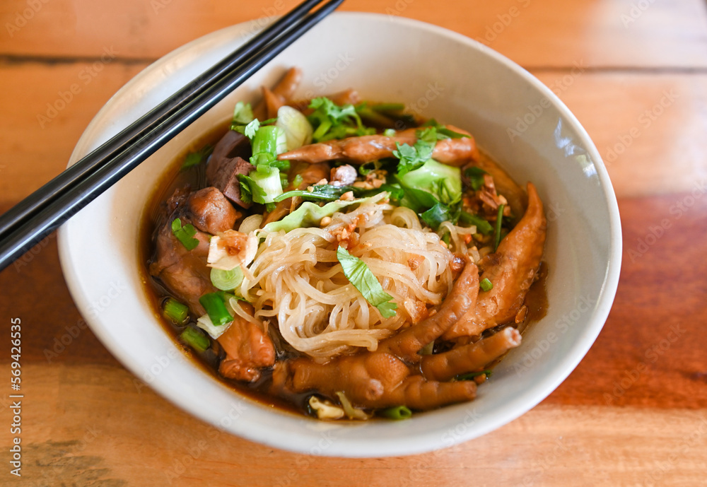chicken noodles with chicken feet and chicken wings and vegetable on soup bowl , Thai food stewed with chinese herbs chicken noodles with chicken feet and chicken wings and vegetable on soup bowl , Thai food stewed with chinese herbs