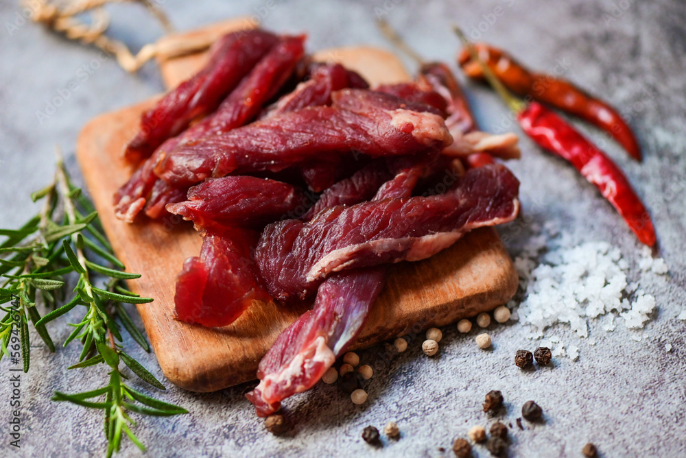 beef jerky with herbs and spices - dried beef on wooden plate, raw dried meat for cooking, dry meat beef in Thailand food beef jerky with herbs and spices - dried beef on wooden plate, raw dried meat for cooking, dry meat beef in Thailand food