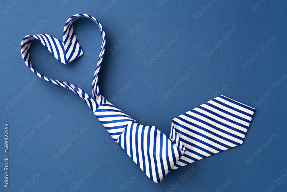 Necktie in heart shape on blue background - obrazy, fototapety, plakaty 