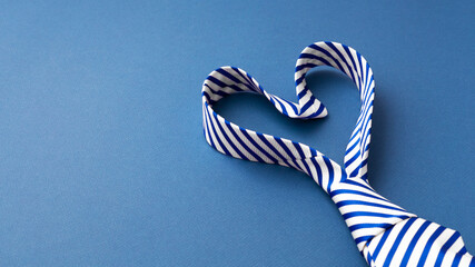 Necktie in heart shape on blue background