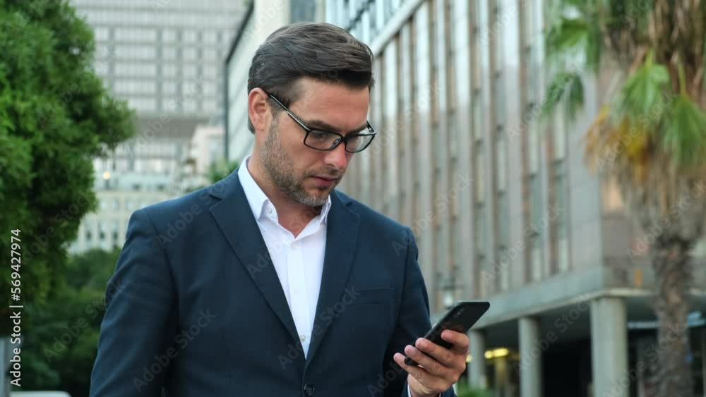 Smiling man wearing formal suit using mobile phone typing text messages. Closeup businessman typing message on mobile phone. Hand of man using texting mobile phone or chat. Smiling man wearing formal suit using mobile phone typing text messages. Closeup businessman typing message on mobile phone. Hand of man using texting mobile phone or chat.
