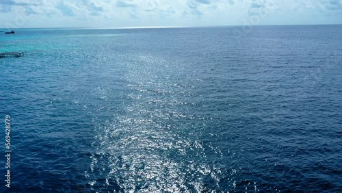 Aerial Lockdown Scenic Shot Of Blue Seascape Against Clouds On Sunny Day - Thulusdhoo, Maldives photo