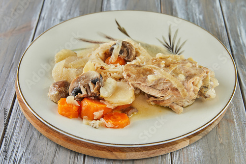 Chicken baked with onions and mushrooms on plate with rice and carrots. French gourmet cuisine