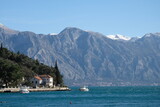 Boka Kotor Bay of the Adriatic Sea in Montenegro.  Houses and boats against the backdrop of snow-capped mountains.