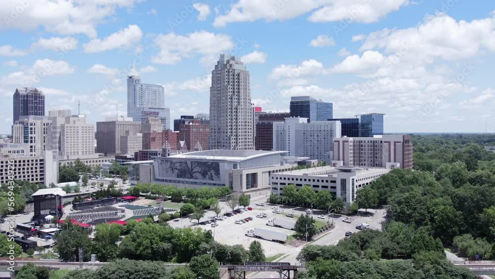 Aerial pull back of Raleigh, NC skyline on beautiful summer day. North Carolina convention center and cityscape.