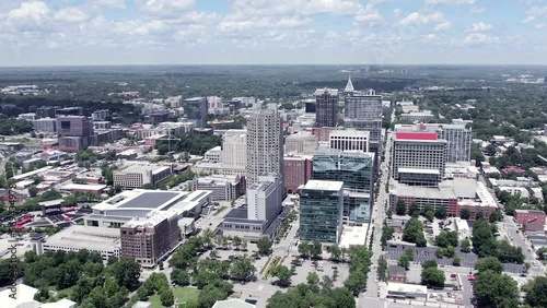 Aerial orbit of Raleigh skyline in NC. American city with drone speed ramp shot on beautiful sunny day.