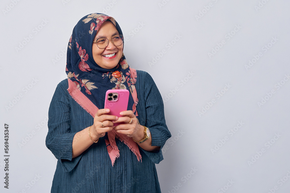 Elderly smiling Asian Muslim woman 50s wearing hijab in glasses holding ...