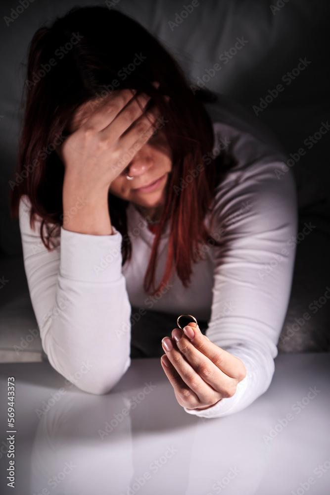 young lonely sad wife after divorce, face sadly covered with hand, mourning wedding ring young lonely sad wife after divorce, face sadly covered with hand, mourning wedding ring