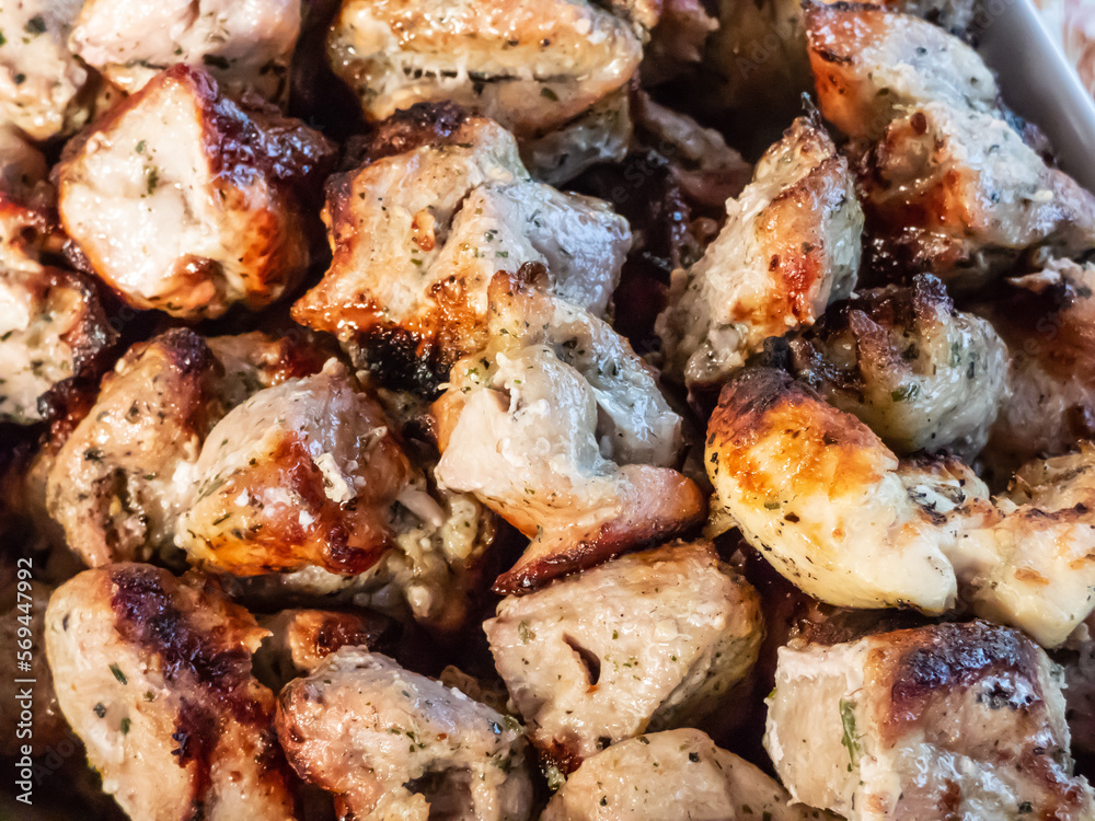 Macro of meat on metal skewers - juicy chicken grilling on fire, coals and smoke in grill. Macro of herbed and seasoned cubes of meat. Grilling meat