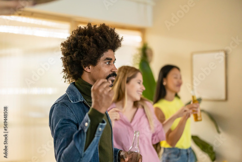 group of multiracial friends celebrate home party dancing and having fun focus on african man