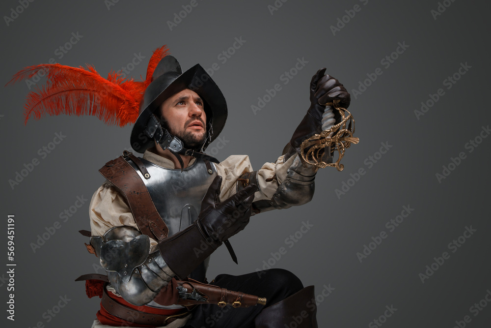 Obraz premium Shot of conquistador with plumed helmet and plate armor holding broken epee.