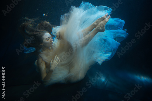 Young beautifull caucasian woman in dress under water