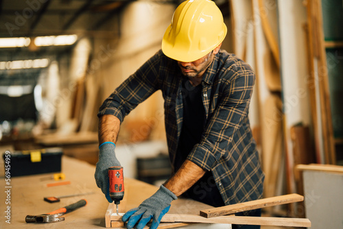 Carpenter man attend to making masterpiece woodworks handcrafted furniture fine measure in wood workshop.