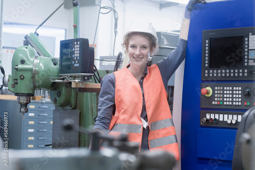 Young female engineer standing at CNC machine in an industrial plant, Freiburg im Breisgau, Baden-Württemberg, Germany photo