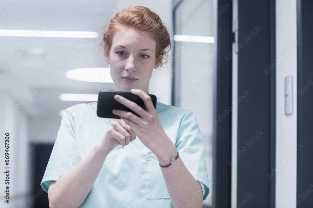 Young female nurse using mobile phone in hospital Young female nurse using mobile phone in hospital