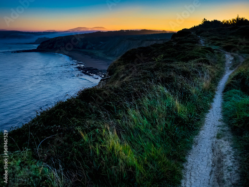 Single trail on cliff by sea at sunrise photo