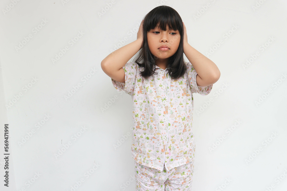 Cute Asian little child girl holding hands over head and looking down isolated on white background. Cute Asian little child girl holding hands over head and looking down isolated on white background.