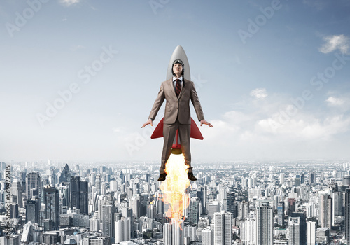 Business person in aviator hat flying on rocket photo