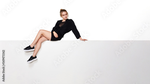 Fotografie lovely young woman with long legs in black dress