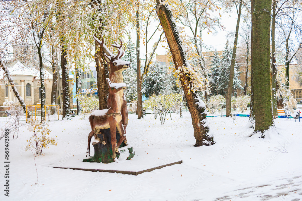 Snow on the deer sculpture in the park. Winter background, selective focus Snow on the deer sculpture in the park. Winter background, selective focus